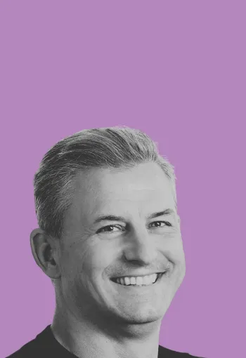 Richard Glasson, CEO of WPP Production headshot in black and white against a purple backdrop.